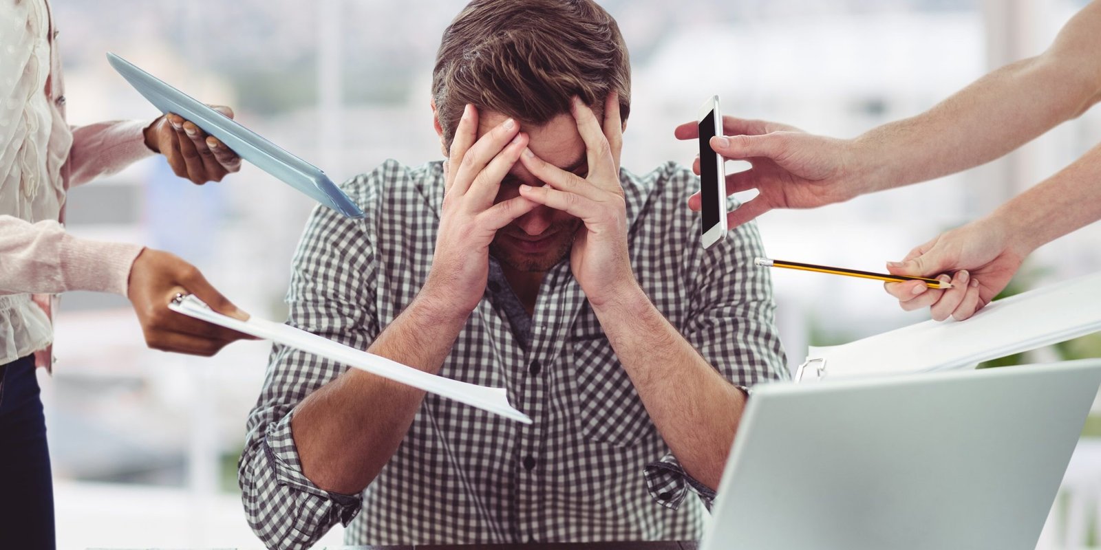 Stressed man frustrated with electronic devices Suplementos para pessoas com problemas de estresse